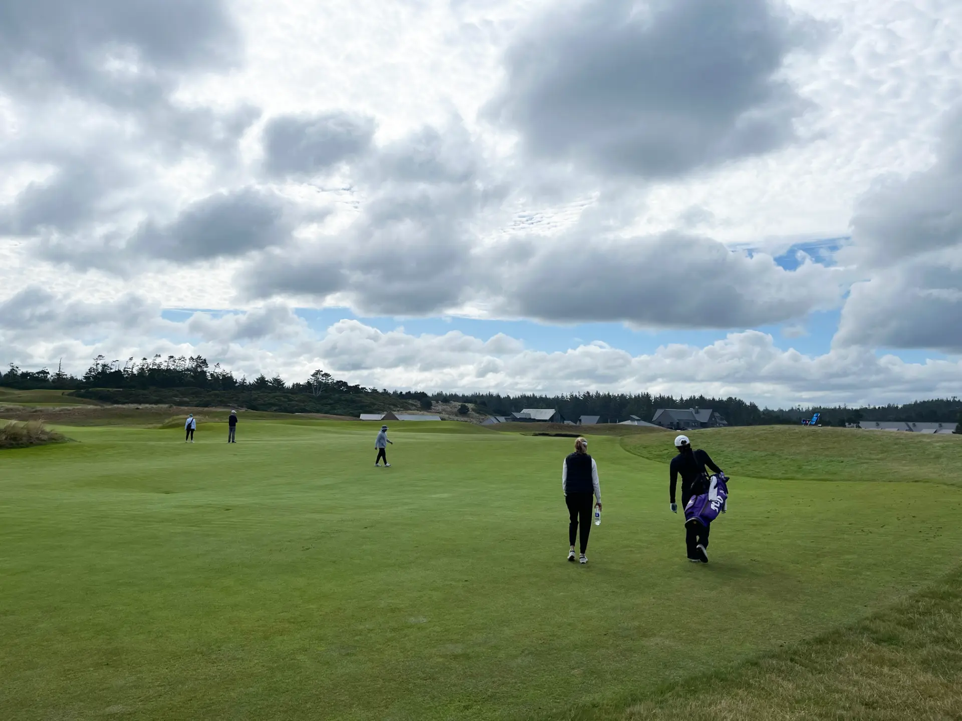 A coach and player walking the fairway together