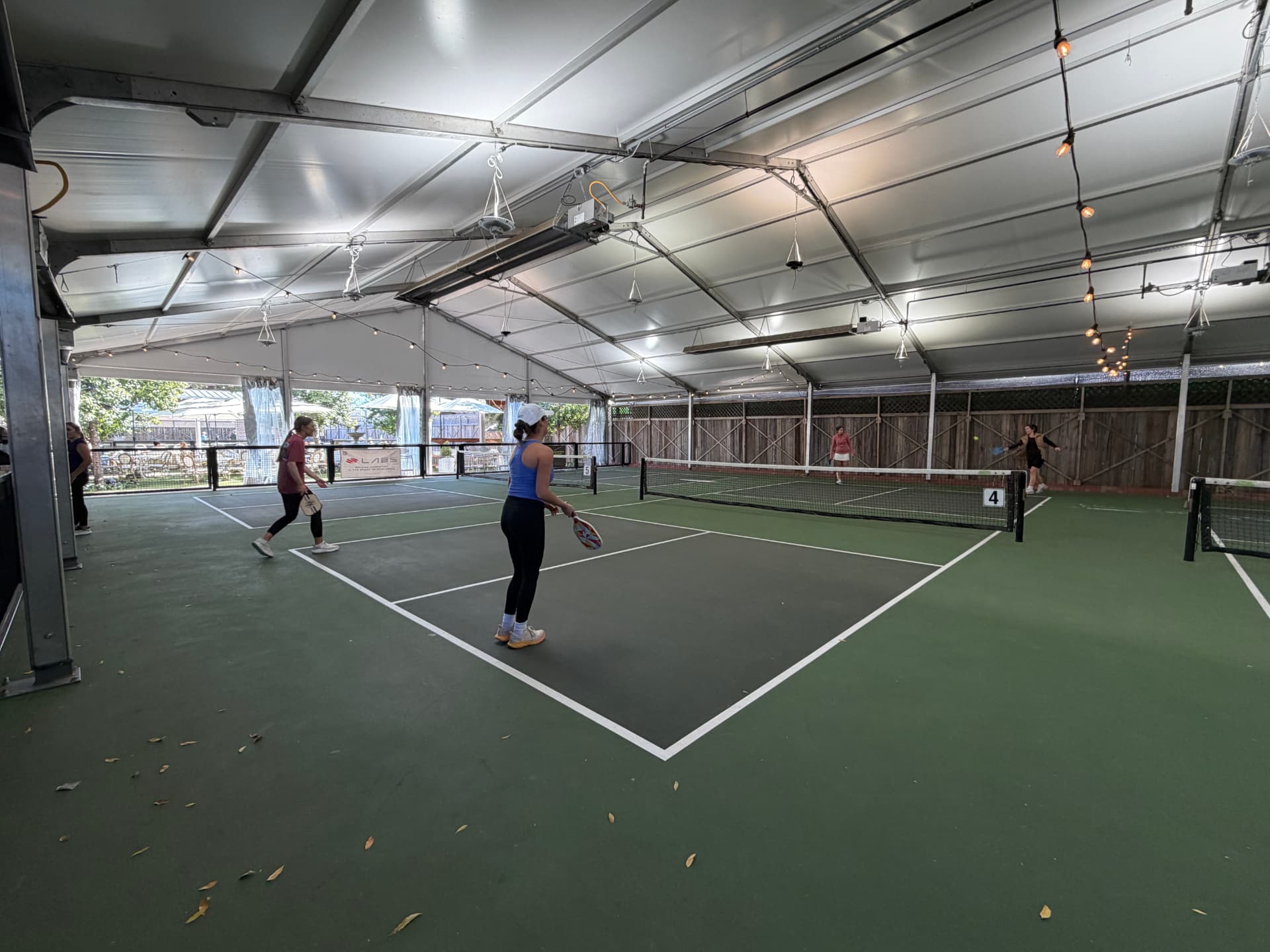 Retreat guests playing pickleball together on a covered court
