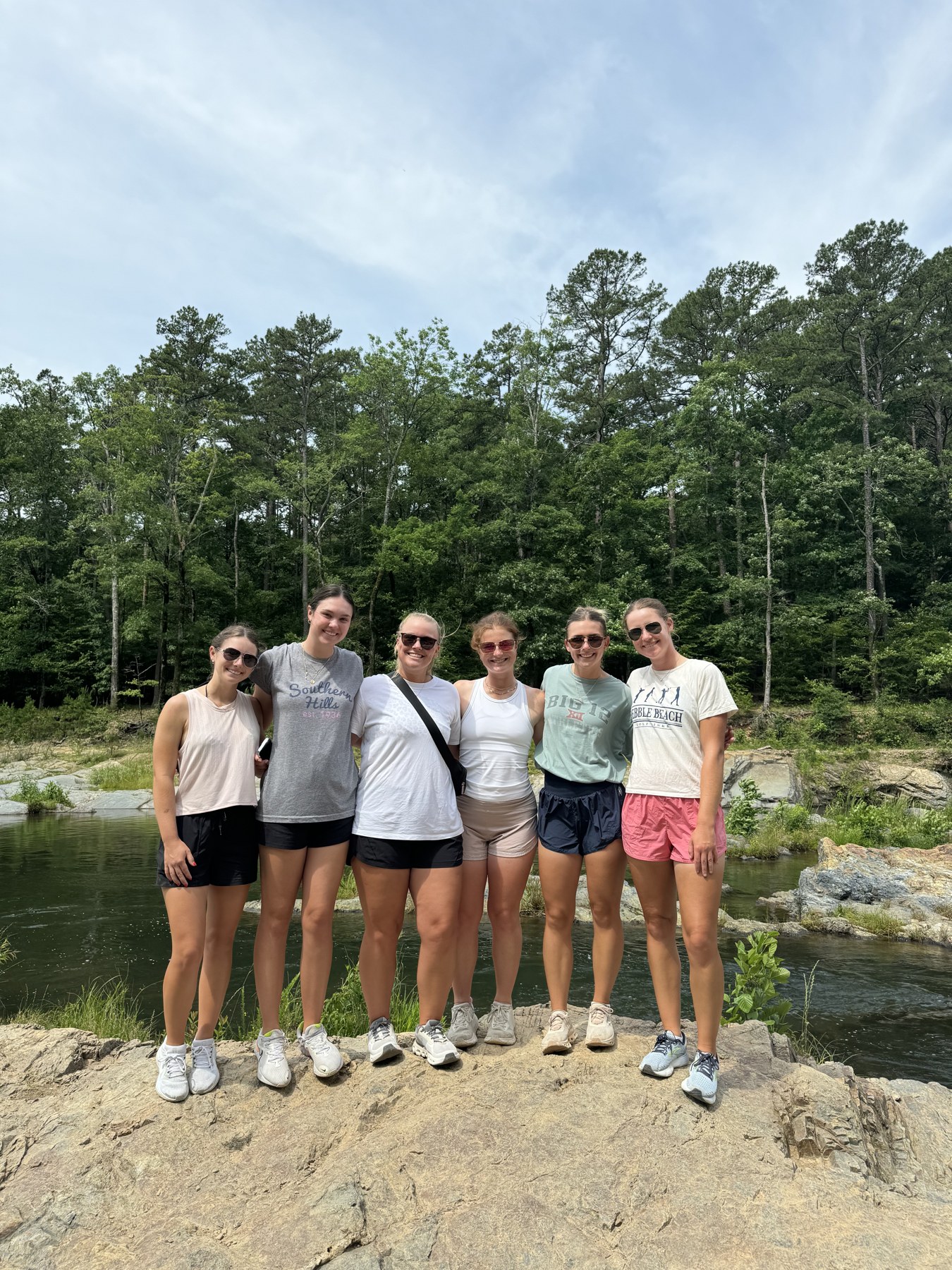 Six retreat guests together on the rocks by the river